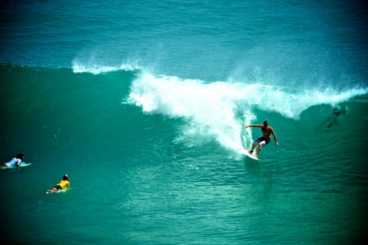 surfer riding a left hand wave in green ocean