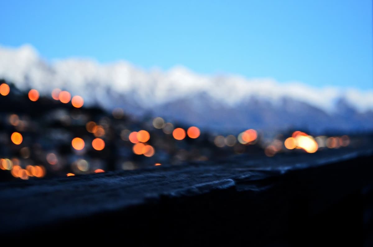 snow capped mountain range above a village at dusk